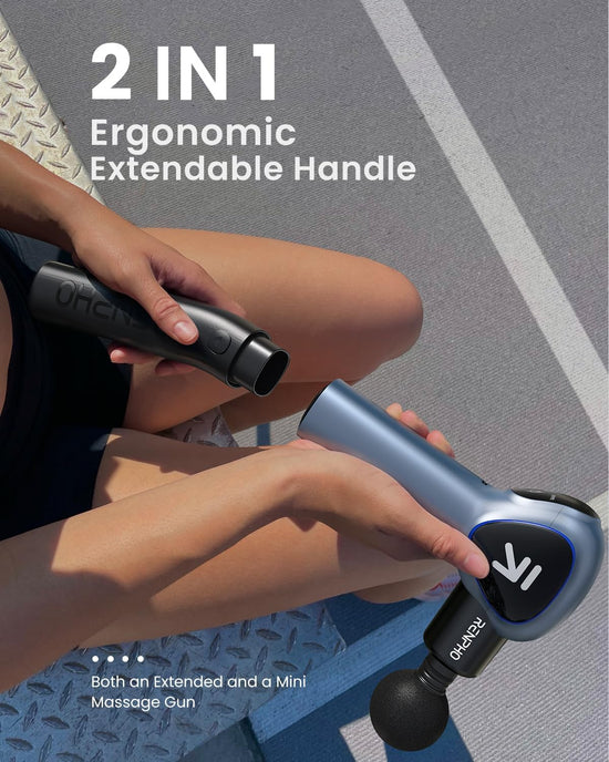 Close-up of a person sitting on an outdoor workout surface, holding two parts of the Renpho UK REACH Extend Massage Gun with its ergonomic extendable handle. The image highlights the "2 IN 1 Ergonomic Extendable Handle" feature, emphasizing its powerful percussion massage for relaxation and recovery.