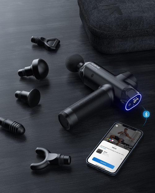 A Renpho Power Massage Gun in black, complete with five interchangeable attachment heads, is showcased on a dark wooden surface next to its carrying case. A smartphone displaying an app is visible with the blue Bluetooth icon indicating a connection to the massage gun, which features an illuminated power button reading "99." This device is ideal for workout recovery and relieving muscle soreness.